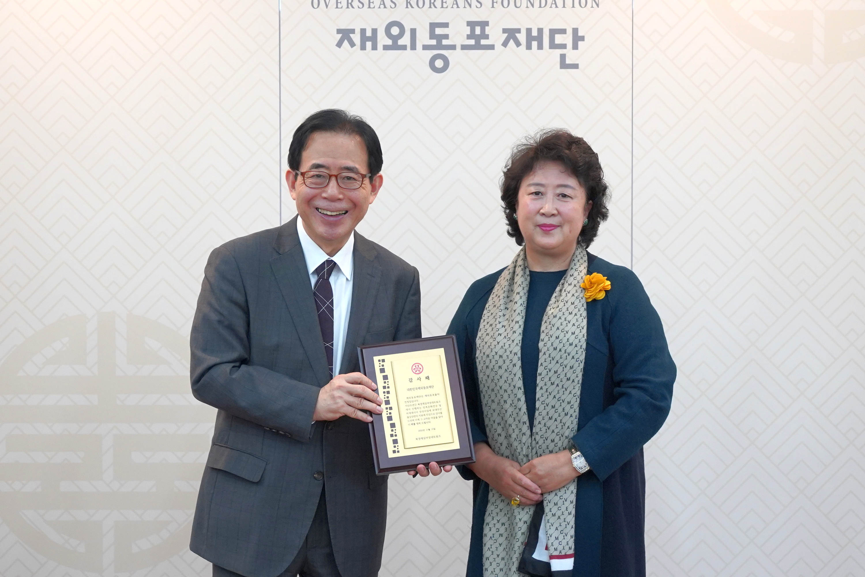 Honorary President Lee Ran delivering the plaque of gratitude to OKF Chairman Kim Sung-kon